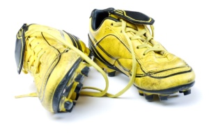 An old yellow pair of broken in soccer cleats. How To Break In Soccer Cleats