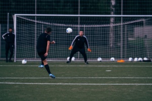 How Wide Is A Soccer Goal? Player shooting at a full size goal