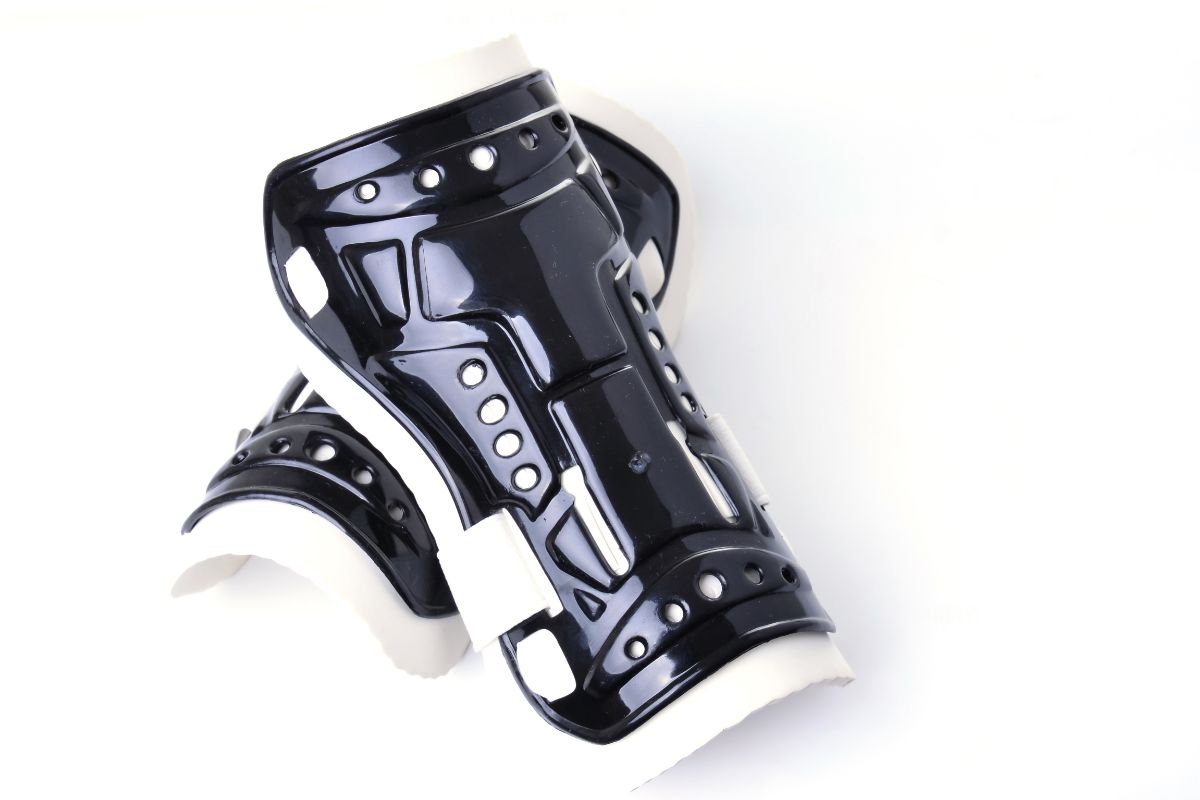 A pair of black and whit shin guards - Shin Guard Care Tips