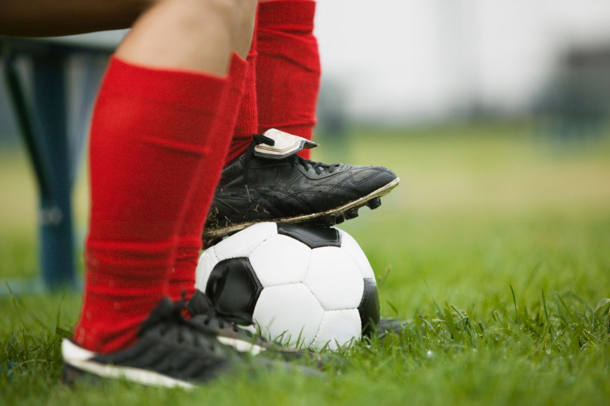 Youth players sitting on the bench wearing their cleats for soccer. 