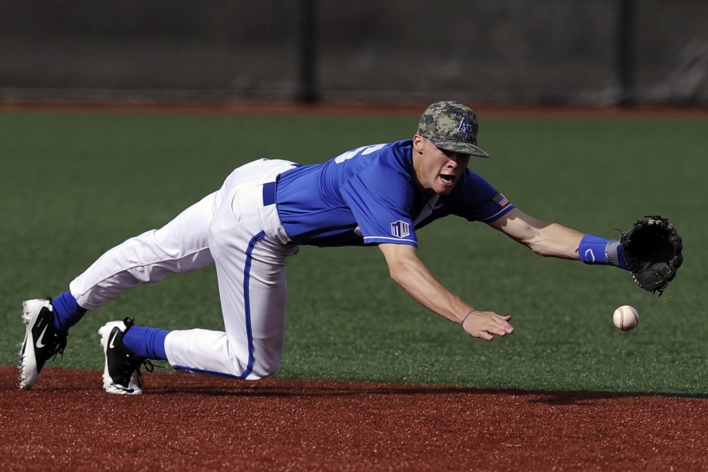 a baseball player diving using a toe stud on his cleats